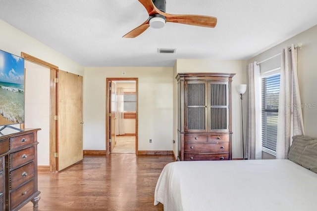 bedroom with wood-type flooring, ceiling fan, and ensuite bathroom