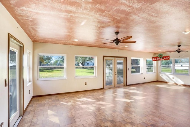 unfurnished sunroom with ceiling fan and french doors