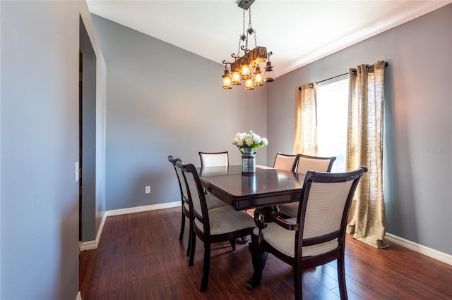 dining area with dark wood-type flooring and a chandelier