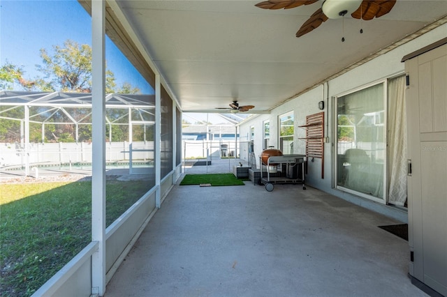 unfurnished sunroom featuring ceiling fan