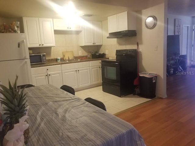 kitchen featuring sink, white cabinetry, black appliances, light hardwood / wood-style floors, and backsplash