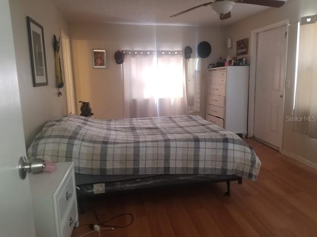 bedroom featuring hardwood / wood-style flooring, ceiling fan, and a textured ceiling