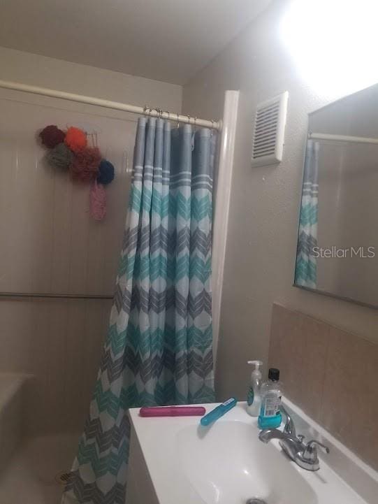 bathroom featuring a shower with curtain and sink