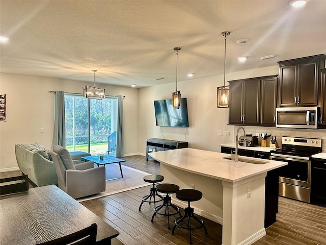 2878 Grand Kemerton Pl, Tampa, FL 33618 - kitchen featuring pendant lighting, sink, stainless steel appliances, and an island with sink