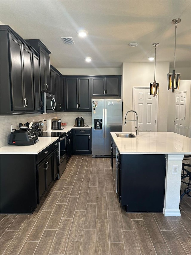 2878 Grand Kemerton Pl, Tampa, FL 33618 - kitchen featuring appliances with stainless steel finishes, a breakfast bar, pendant lighting, an island with sink, and sink