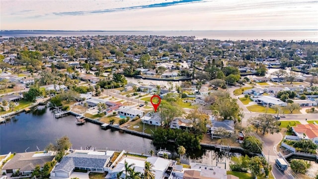 aerial view at dusk featuring a water view