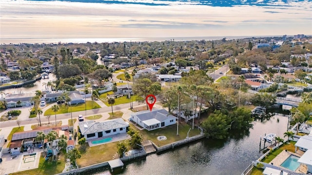 aerial view at dusk featuring a water view