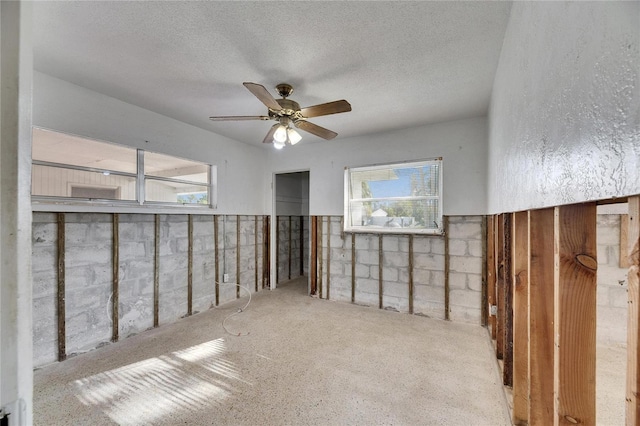 empty room featuring ceiling fan and a textured ceiling