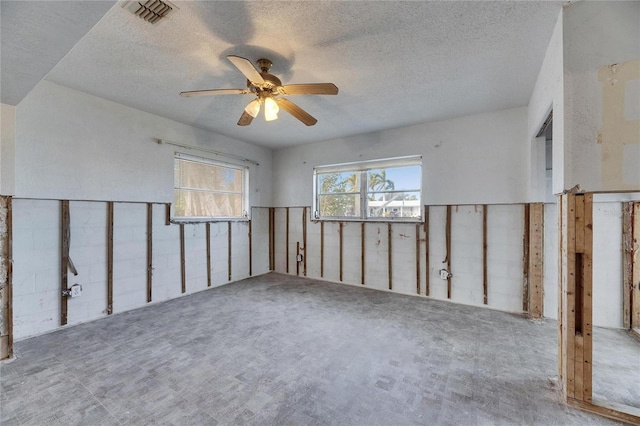 unfurnished room featuring ceiling fan and a textured ceiling