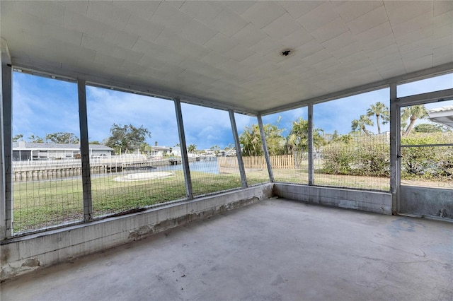 unfurnished sunroom featuring a water view