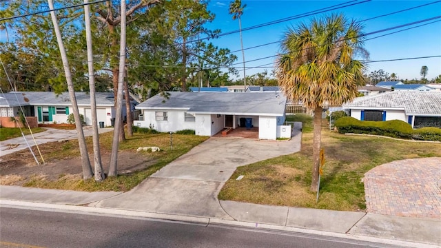 ranch-style home featuring a carport and a front lawn