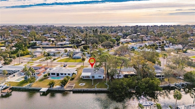 aerial view at dusk featuring a water view