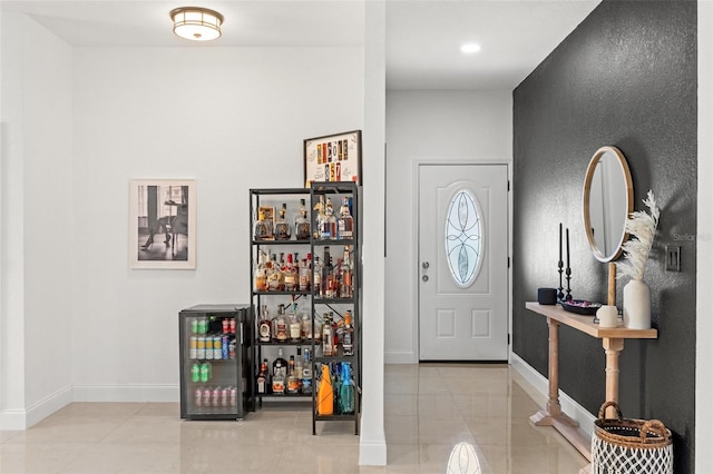 tiled entryway featuring bar area and wine cooler