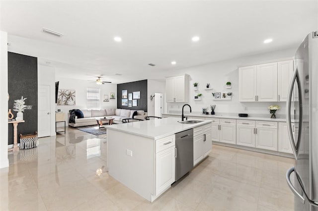 kitchen featuring stainless steel appliances, white cabinetry, a kitchen island with sink, and sink