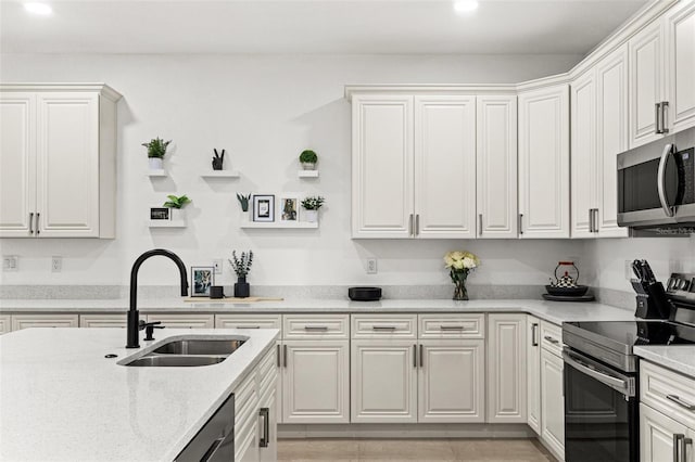 kitchen with white cabinetry, stainless steel appliances, and sink