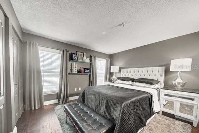 bedroom with dark hardwood / wood-style floors and a textured ceiling