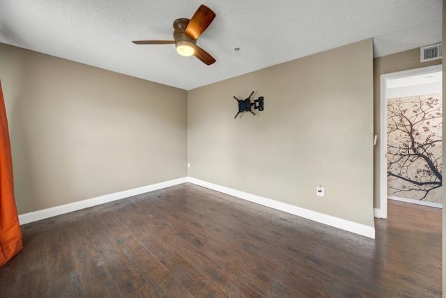 empty room with dark hardwood / wood-style flooring, a textured ceiling, and ceiling fan