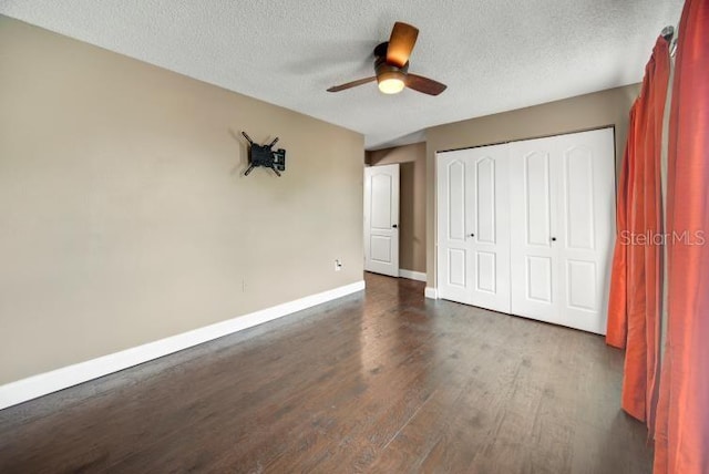 unfurnished bedroom featuring dark hardwood / wood-style flooring, a textured ceiling, a closet, and ceiling fan