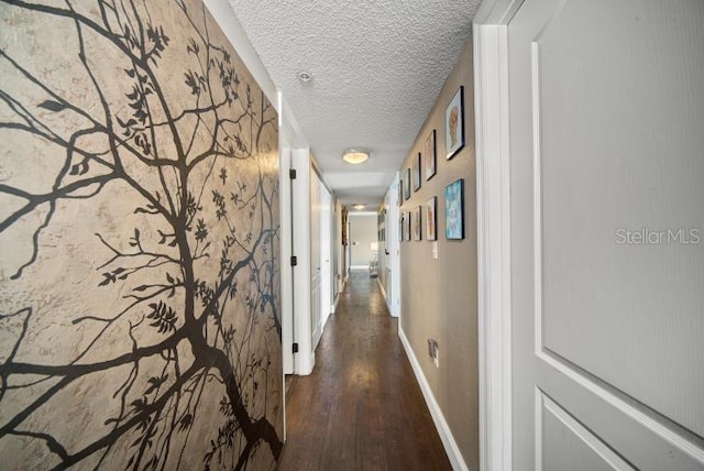 hallway featuring dark hardwood / wood-style floors and a textured ceiling