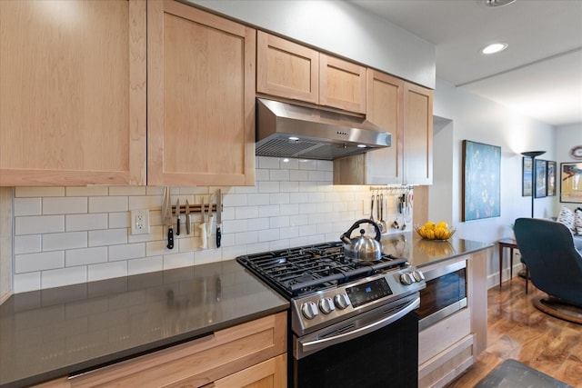 kitchen featuring decorative backsplash, wood-type flooring, stainless steel appliances, and light brown cabinets