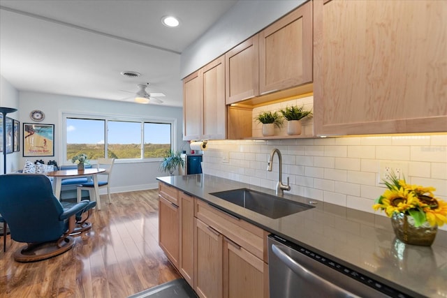 kitchen with dark wood-type flooring, sink, tasteful backsplash, light brown cabinets, and stainless steel dishwasher