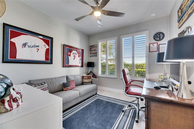 office area with ceiling fan and baseboards