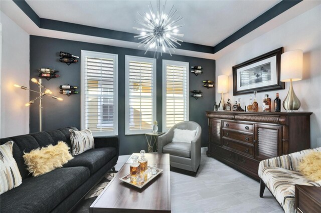 living area featuring a chandelier and a tray ceiling