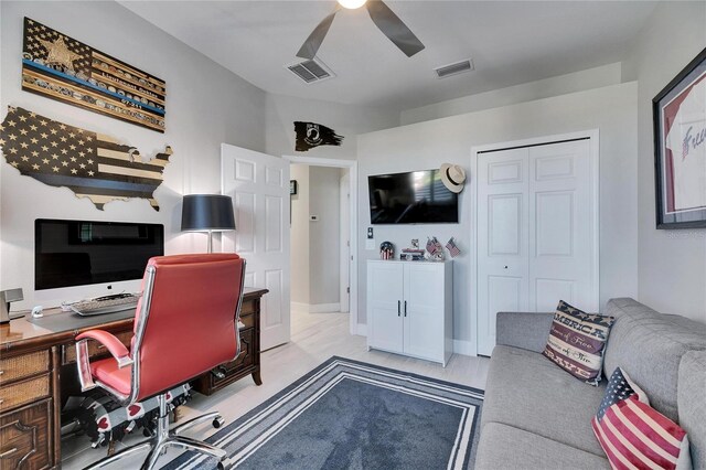 office space featuring light wood-type flooring, visible vents, and a ceiling fan