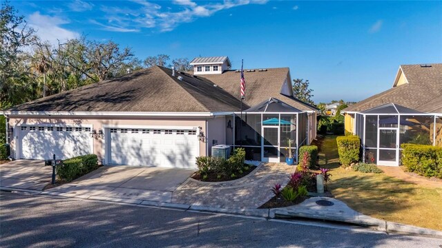 view of front of property with stucco siding, a shingled roof, an attached garage, glass enclosure, and driveway