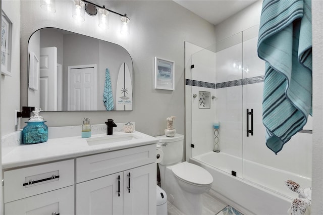 full bathroom with toilet, shower / bath combination with glass door, and vanity