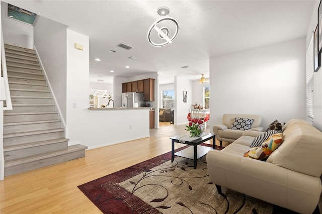 living room with ceiling fan and light hardwood / wood-style floors