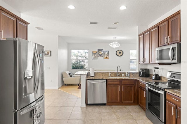 kitchen featuring light tile patterned floors, plenty of natural light, stainless steel appliances, and sink