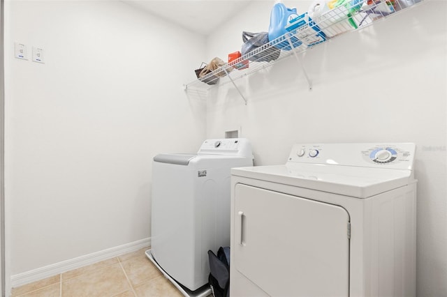 laundry room with light tile patterned floors and washing machine and dryer