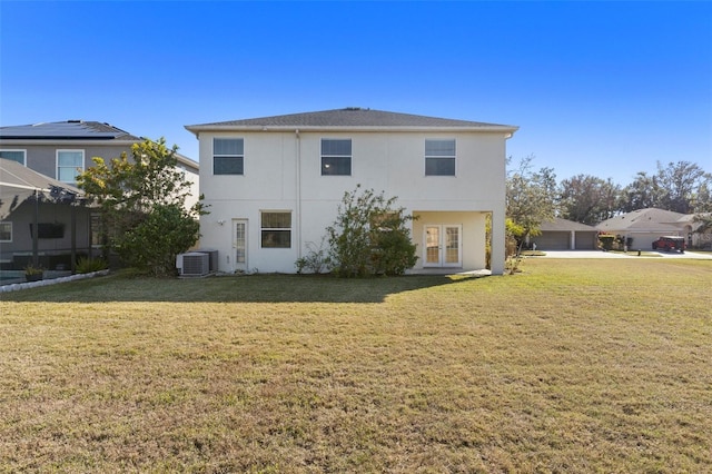 back of property with central AC and a yard