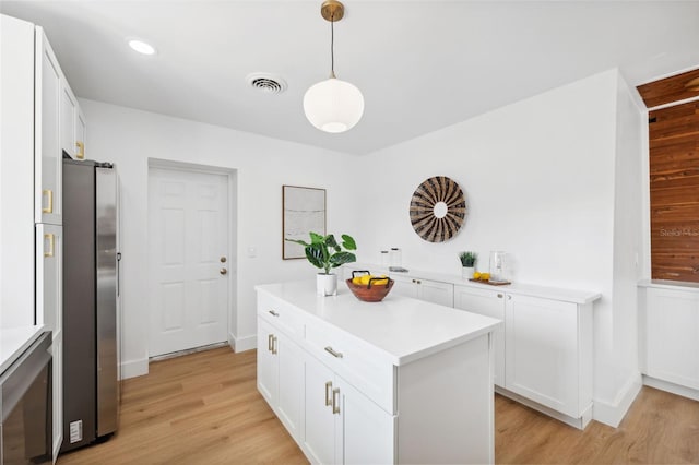 kitchen with white cabinetry, a center island, light hardwood / wood-style flooring, hanging light fixtures, and stainless steel refrigerator