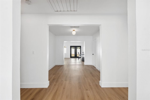 hall featuring light hardwood / wood-style flooring and french doors