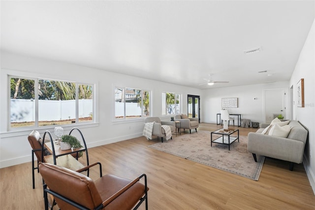 living room with light hardwood / wood-style flooring and ceiling fan