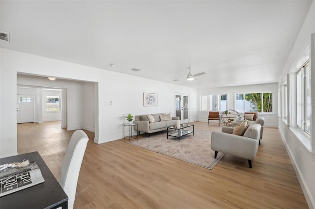 living room featuring ceiling fan, light hardwood / wood-style floors, and a healthy amount of sunlight