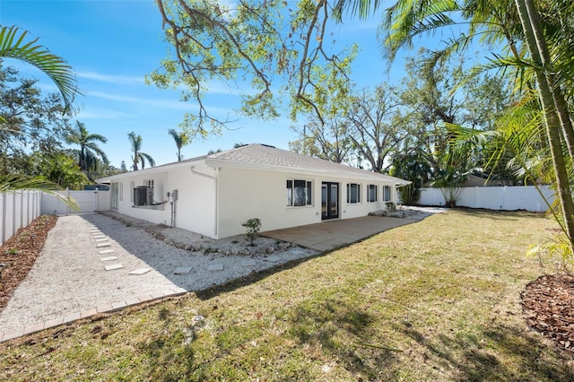 rear view of house featuring cooling unit, a yard, and a patio area