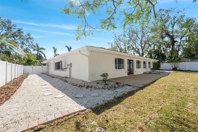 rear view of house with a yard, central AC unit, and a patio