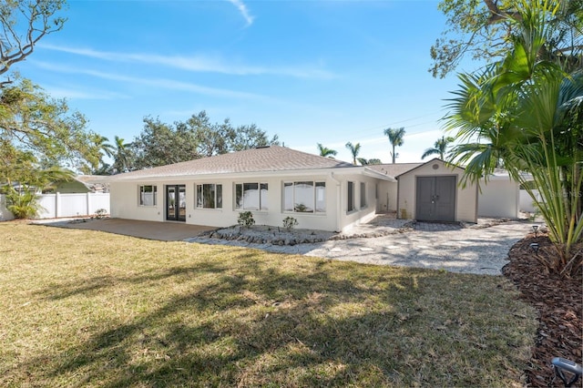 back of property featuring a storage shed, a yard, and a patio