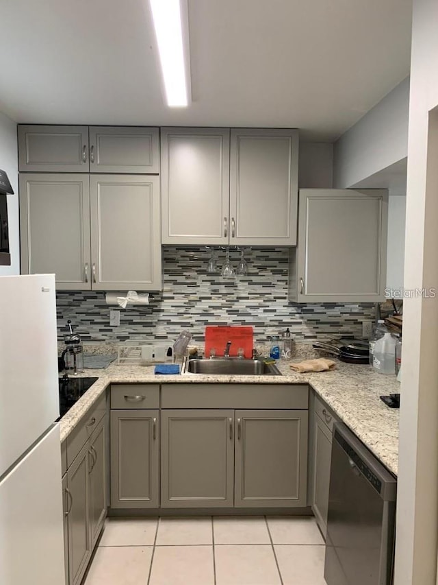 kitchen featuring gray cabinets, dishwasher, and white refrigerator