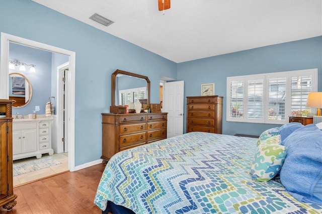 bedroom with ceiling fan, sink, light hardwood / wood-style floors, and ensuite bath