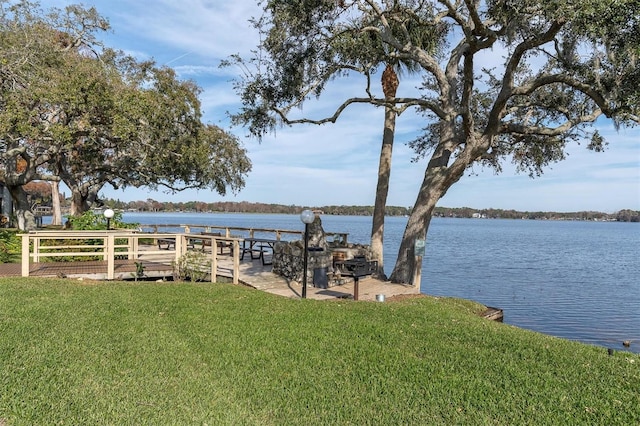 dock area with a water view and a lawn