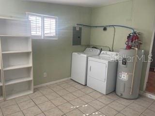 laundry room with water heater, washing machine and dryer, light tile patterned floors, and electric panel