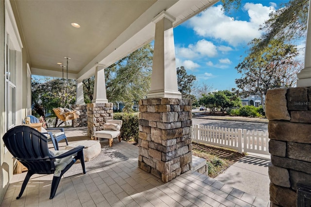 view of patio / terrace with a porch and fence