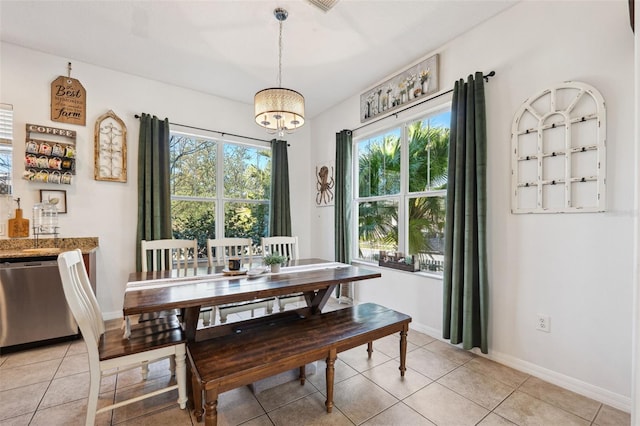 dining area with light tile patterned flooring, baseboards, and an inviting chandelier