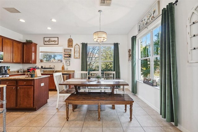 dining area with light tile patterned flooring, visible vents, and baseboards