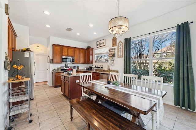 dining space featuring arched walkways, visible vents, recessed lighting, and light tile patterned flooring