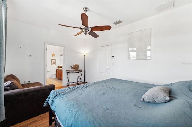 bedroom featuring a ceiling fan, visible vents, connected bathroom, and light wood-style flooring